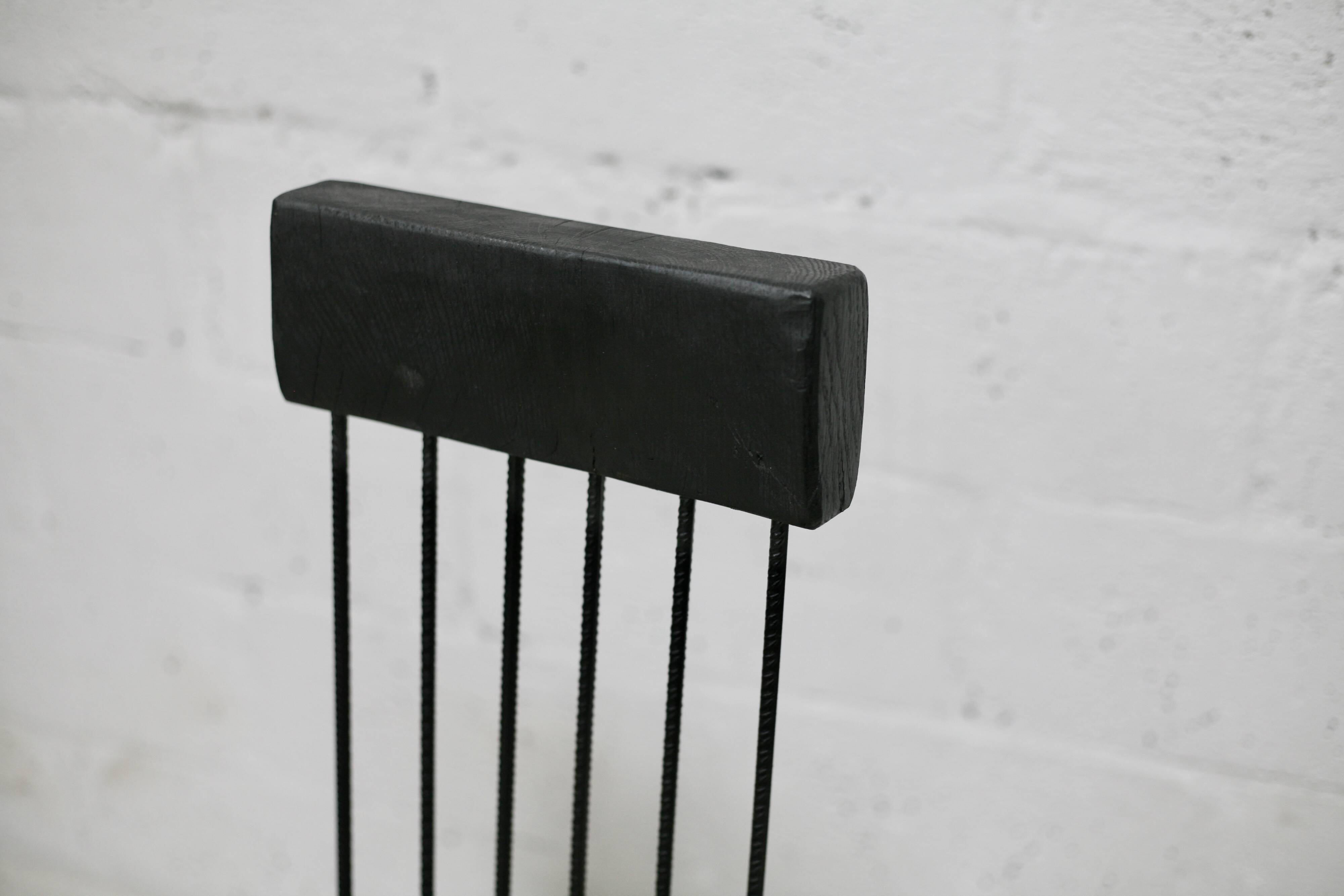 Brutalist chair, black-stained raw wood, steel. Work from the 1970s
