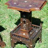 A folding chair and a carved Syrian table with 19th-century mother-of-pearl inlays.