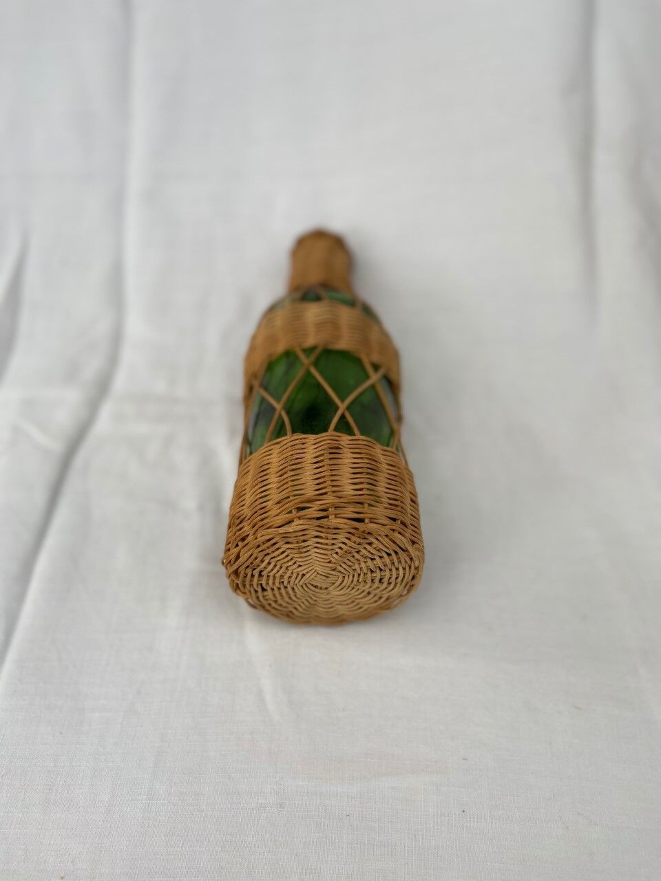 Green bottle with wicker decoration