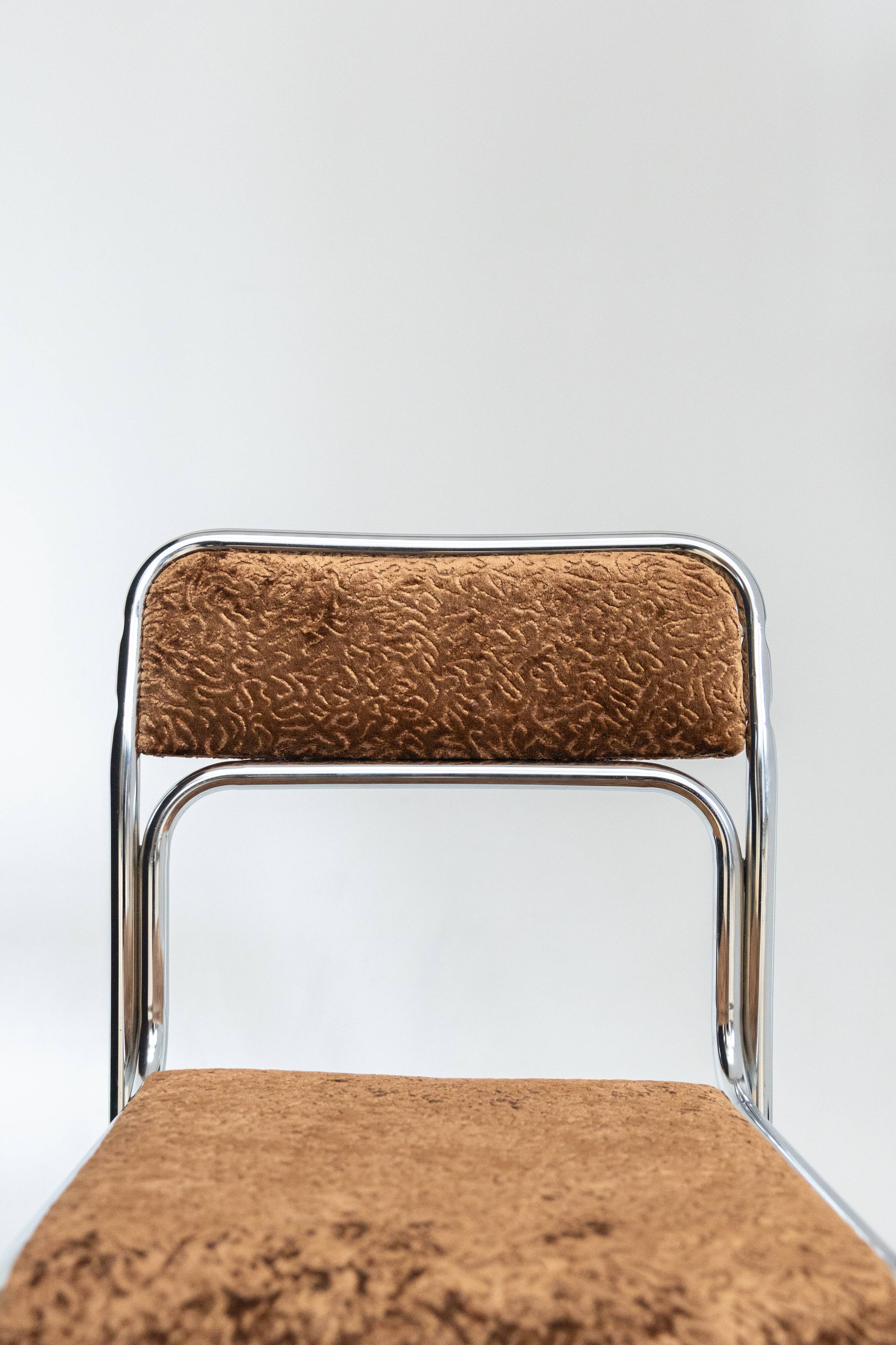 Chrome dining chair upholstered in brown bitten velvet.