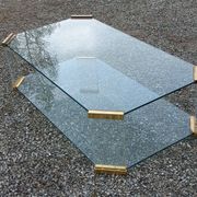 1970s designer coffee table in glass, plexiglass, and gold metal.