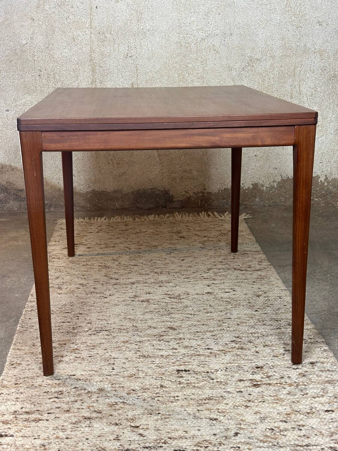 Extendable teak and teak veneer dining table
