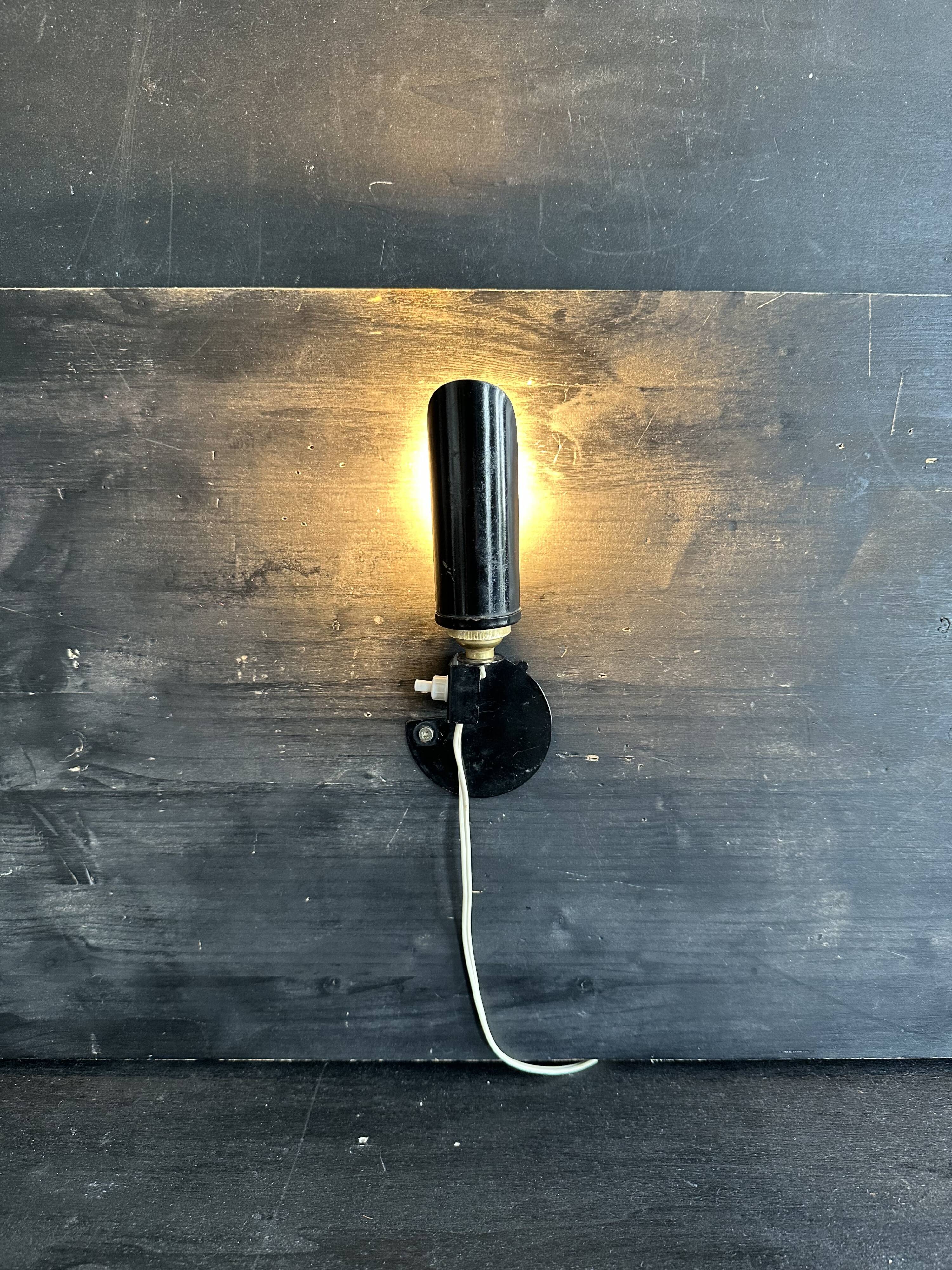 Old black metal and brass wall light, adjustable, 1930s.