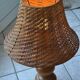 Large wooden lamp with a woven rattan shade.