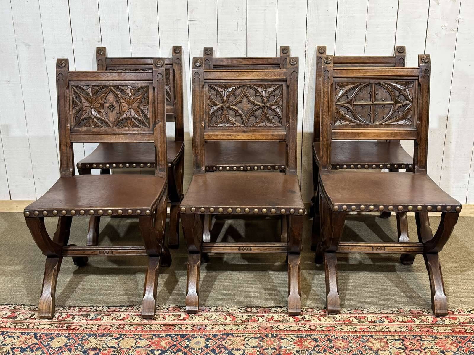 Suite de 6 chaises et 2 fauteuils en chêne et cuir à décor gothique