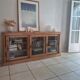 Antique wooden sideboard with three sliding glass doors.