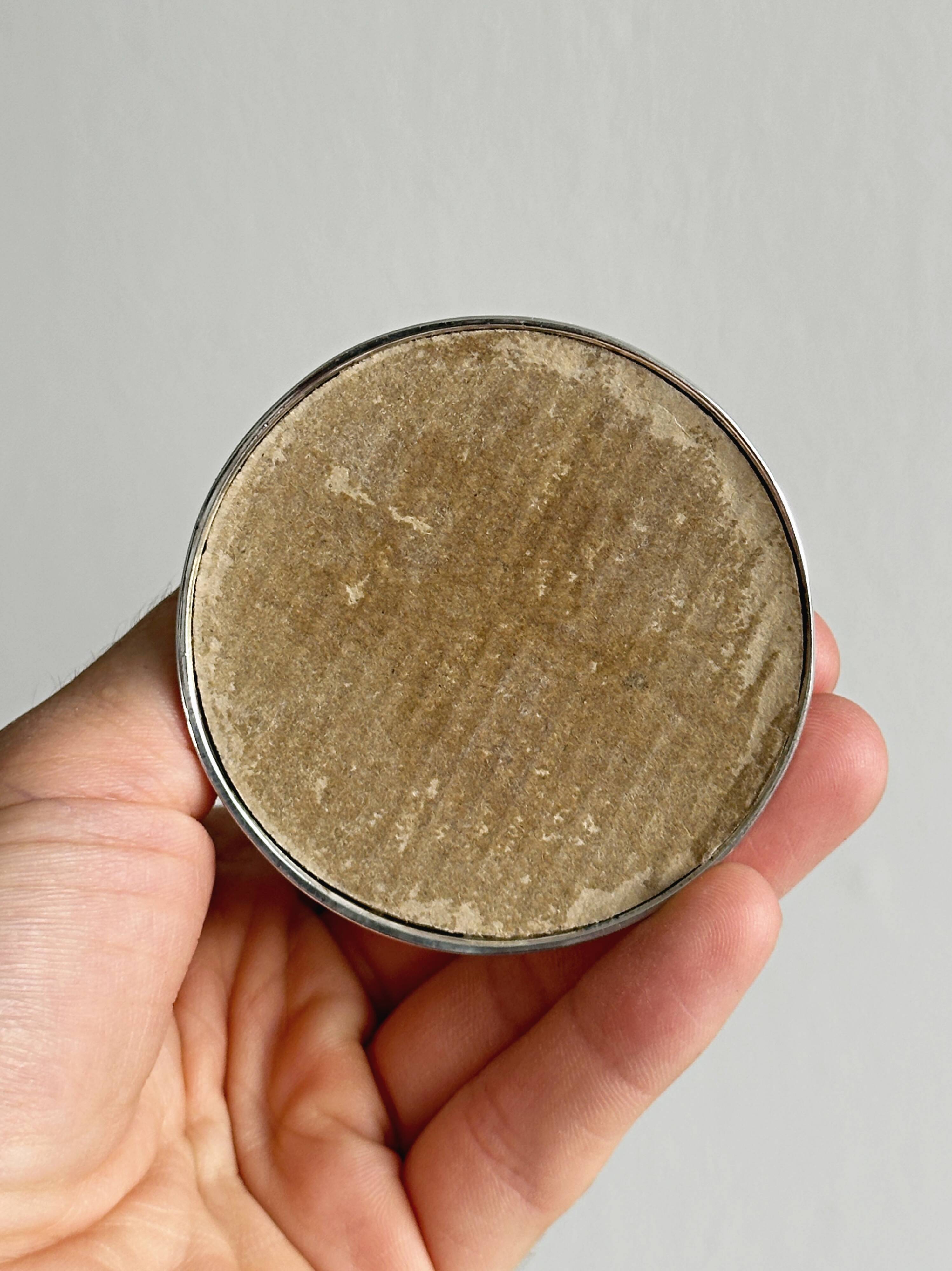 A pair of small silver-white metal candle holders.