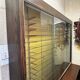 Vintage wooden and glass display cabinet, 15 shelves, gold background.