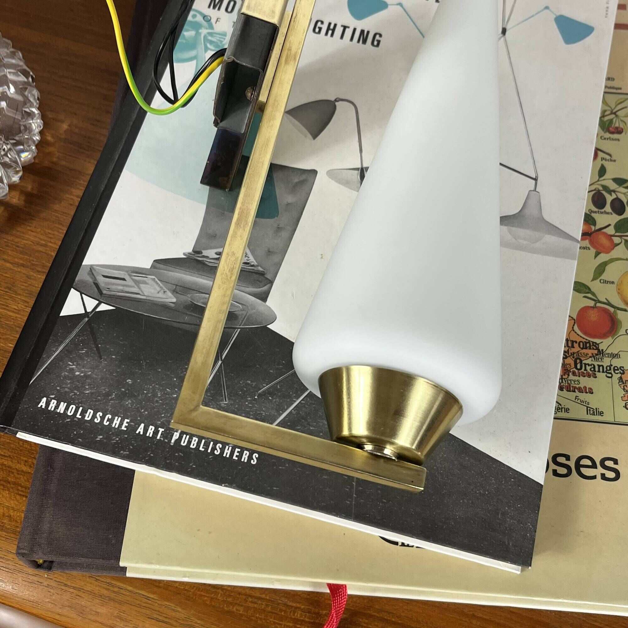 Vintage brass wall light with a white glass spindle shade from the 1950s-1960s.