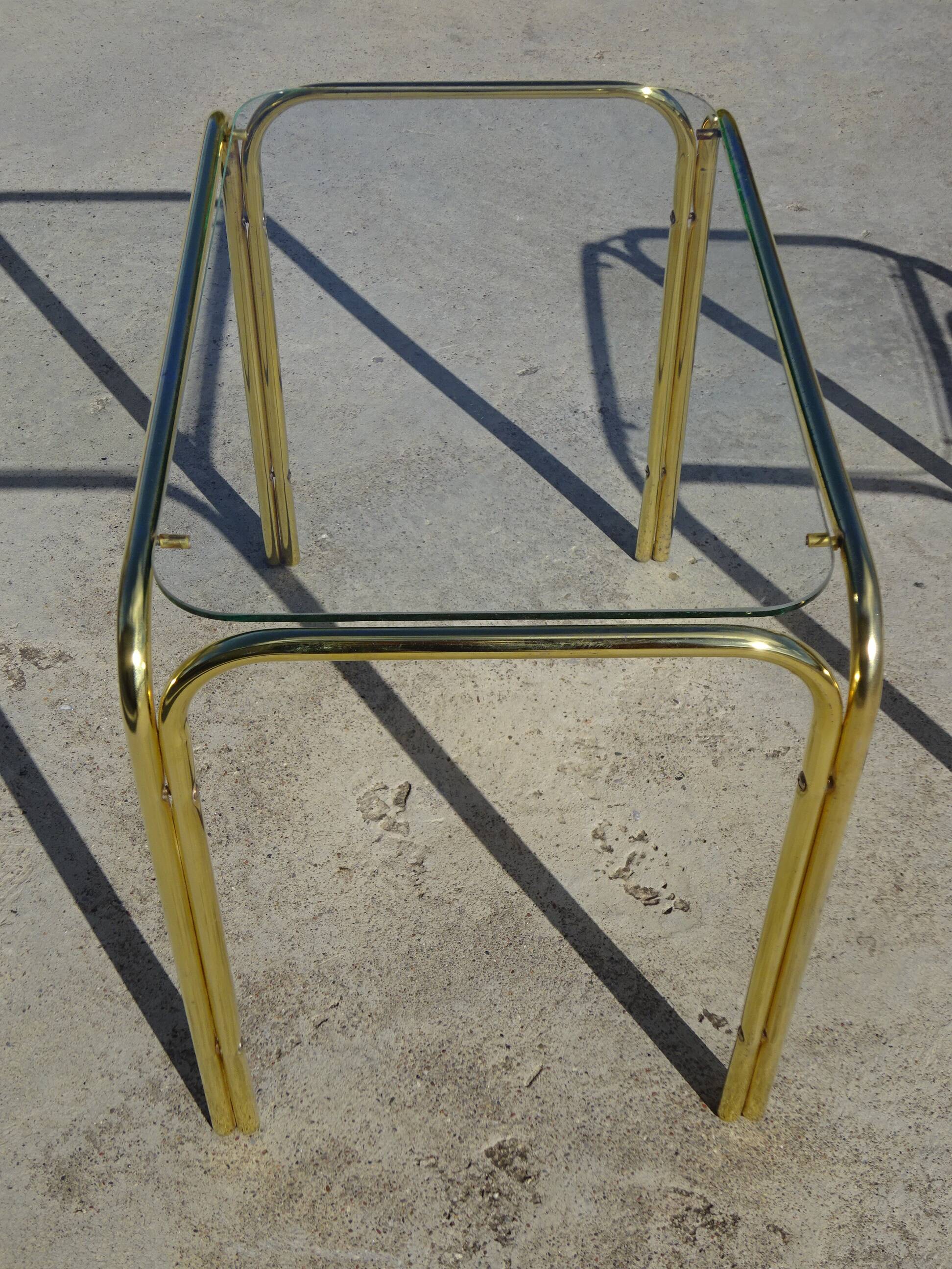 Nested tubular tables in gold metal.