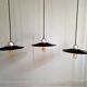 Three industrial suspensions in black enamelled sheet metal.