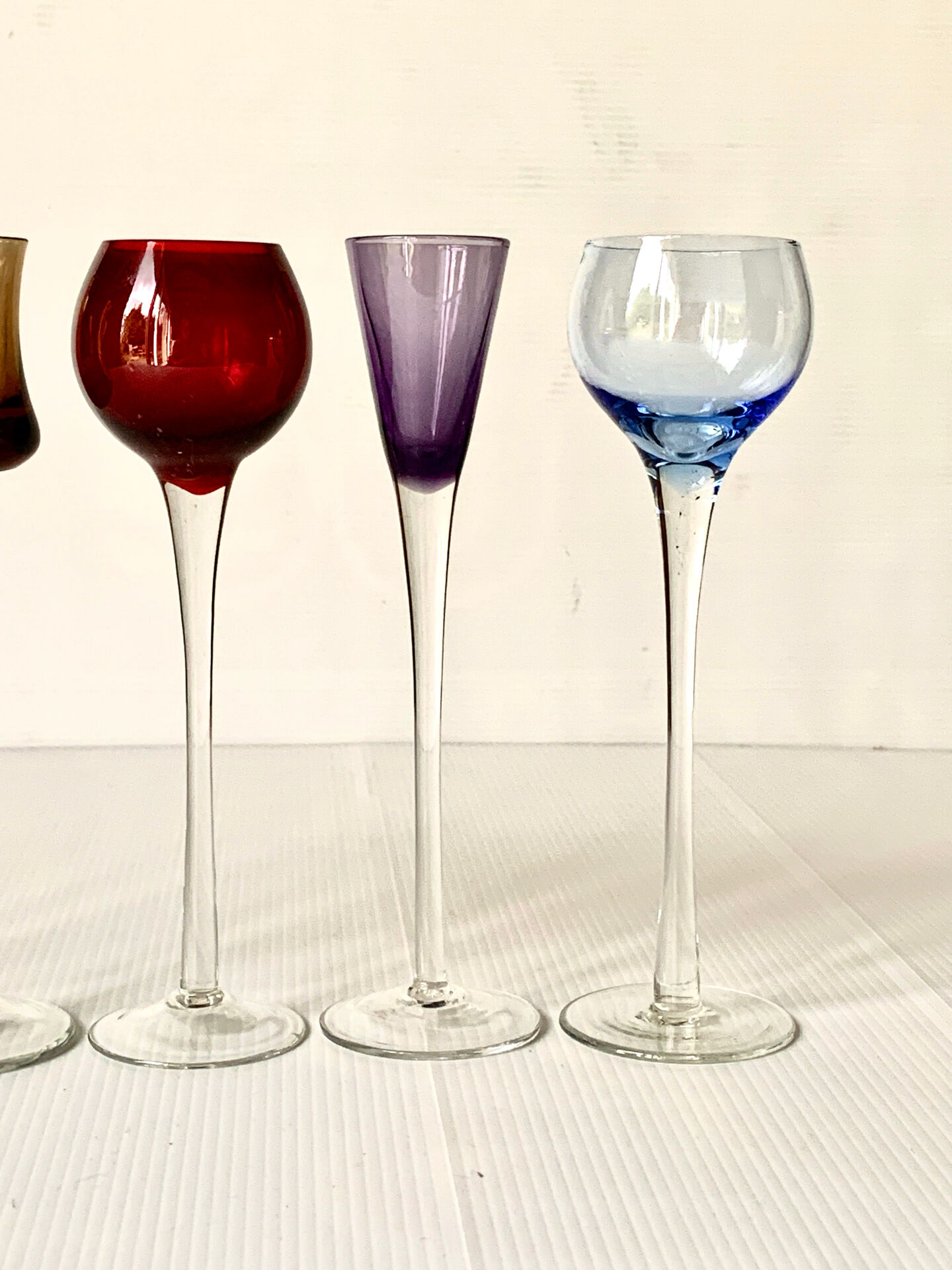 Cinq verres à liqueur colorés sur pied