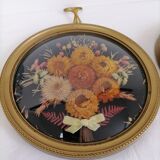 Dried flowers under curved glass frame