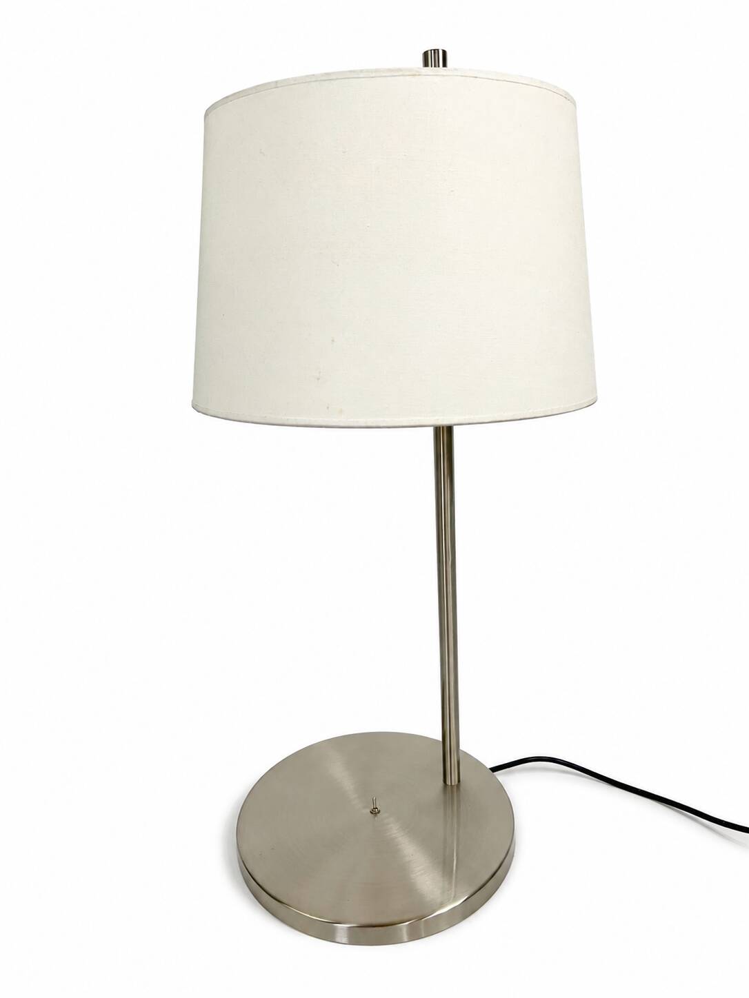 Large brushed metal table lamp with an ecru shade.