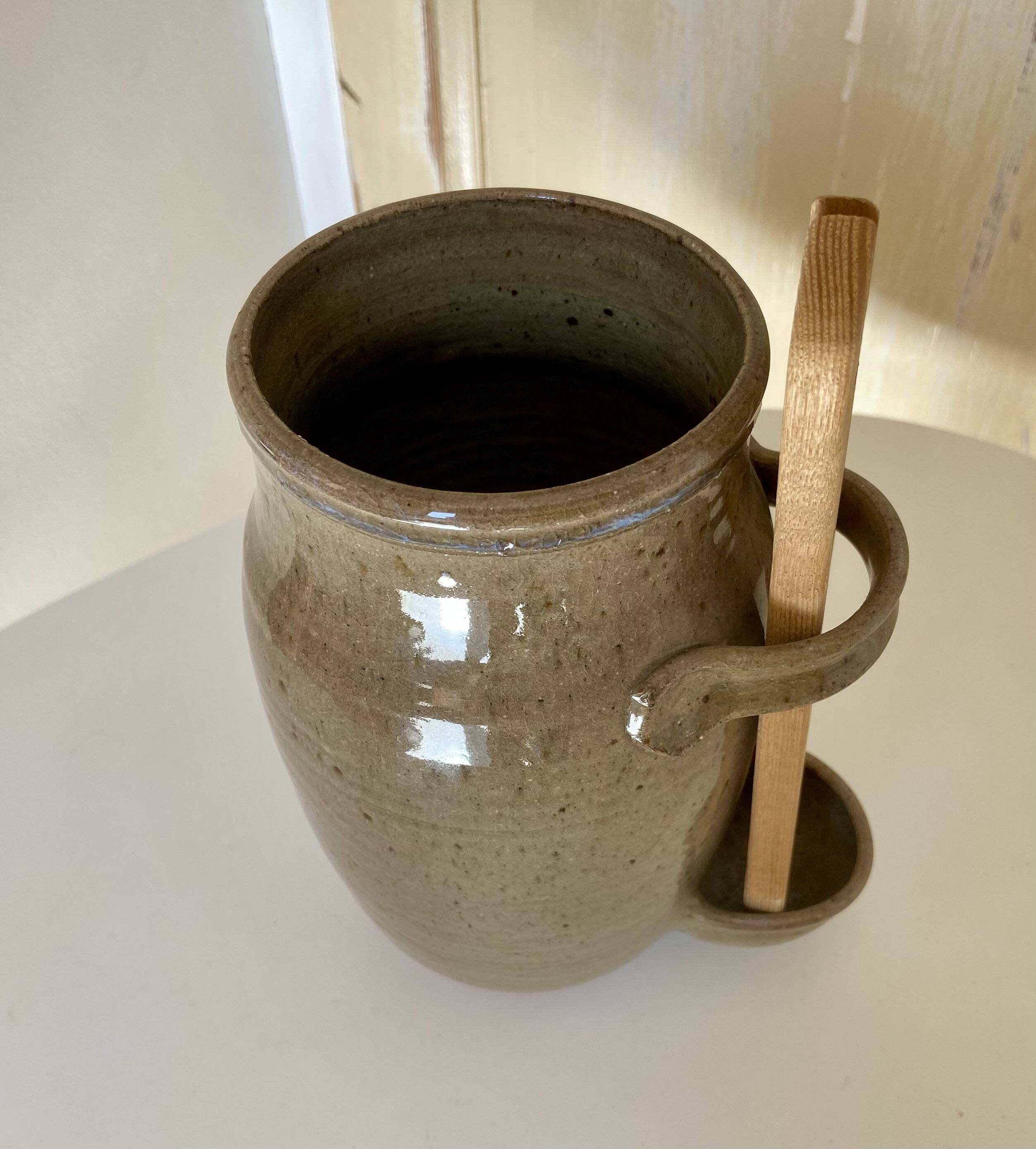 Old varnished stoneware pickle pot with tongs