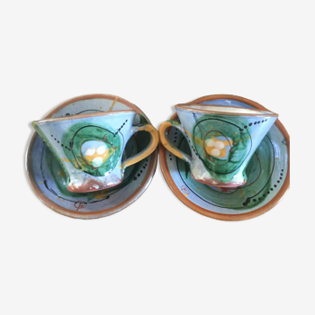 Two cups and their hand-painted ceramic saucer