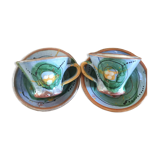 Two cups and their hand-painted ceramic saucer