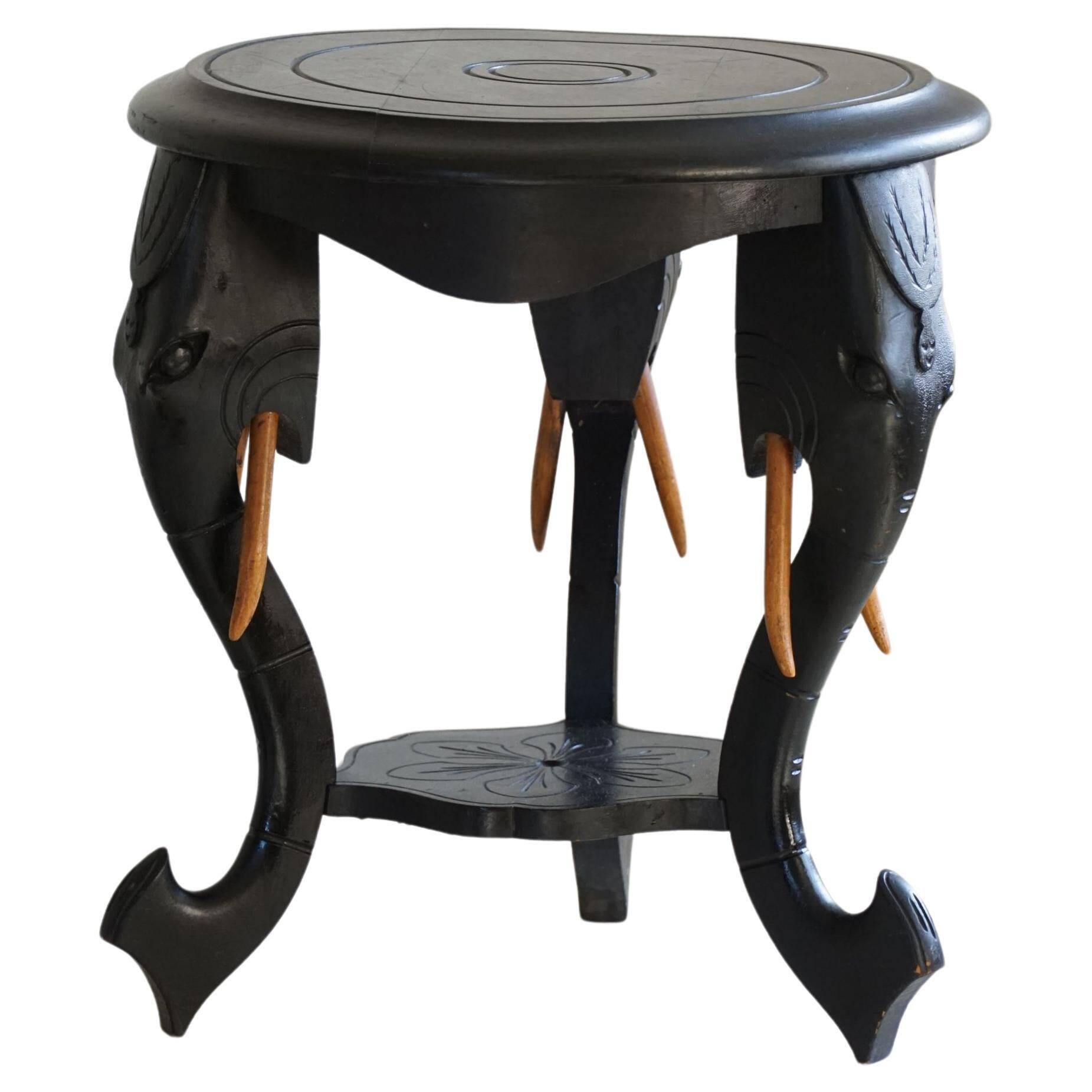 Side table in hardwood ebony with three elephant head-shaped legs, Eastern India, 1920s.