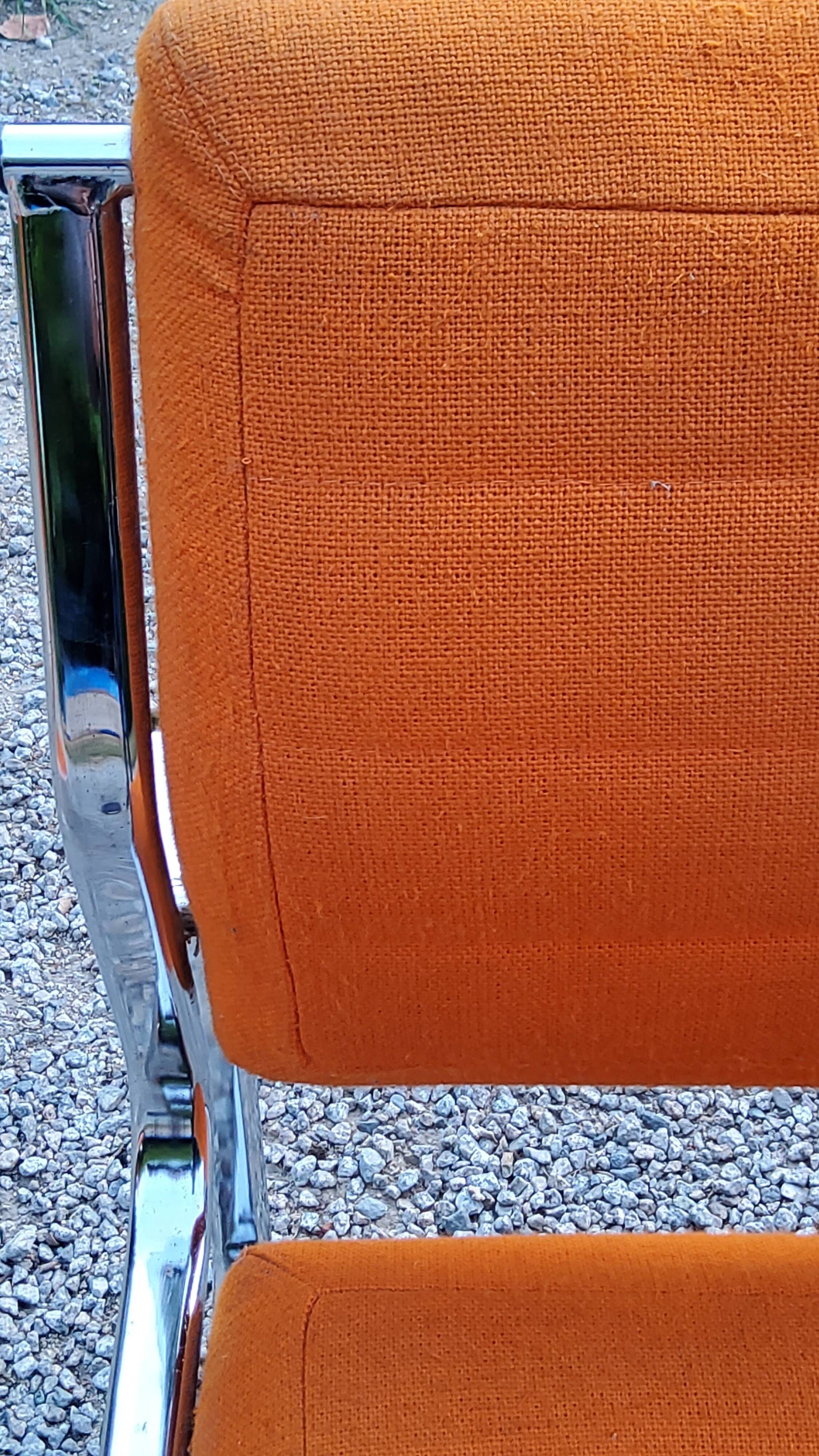 Pair of designer armchairs in orange fabrics and chrome tubes from the 70s