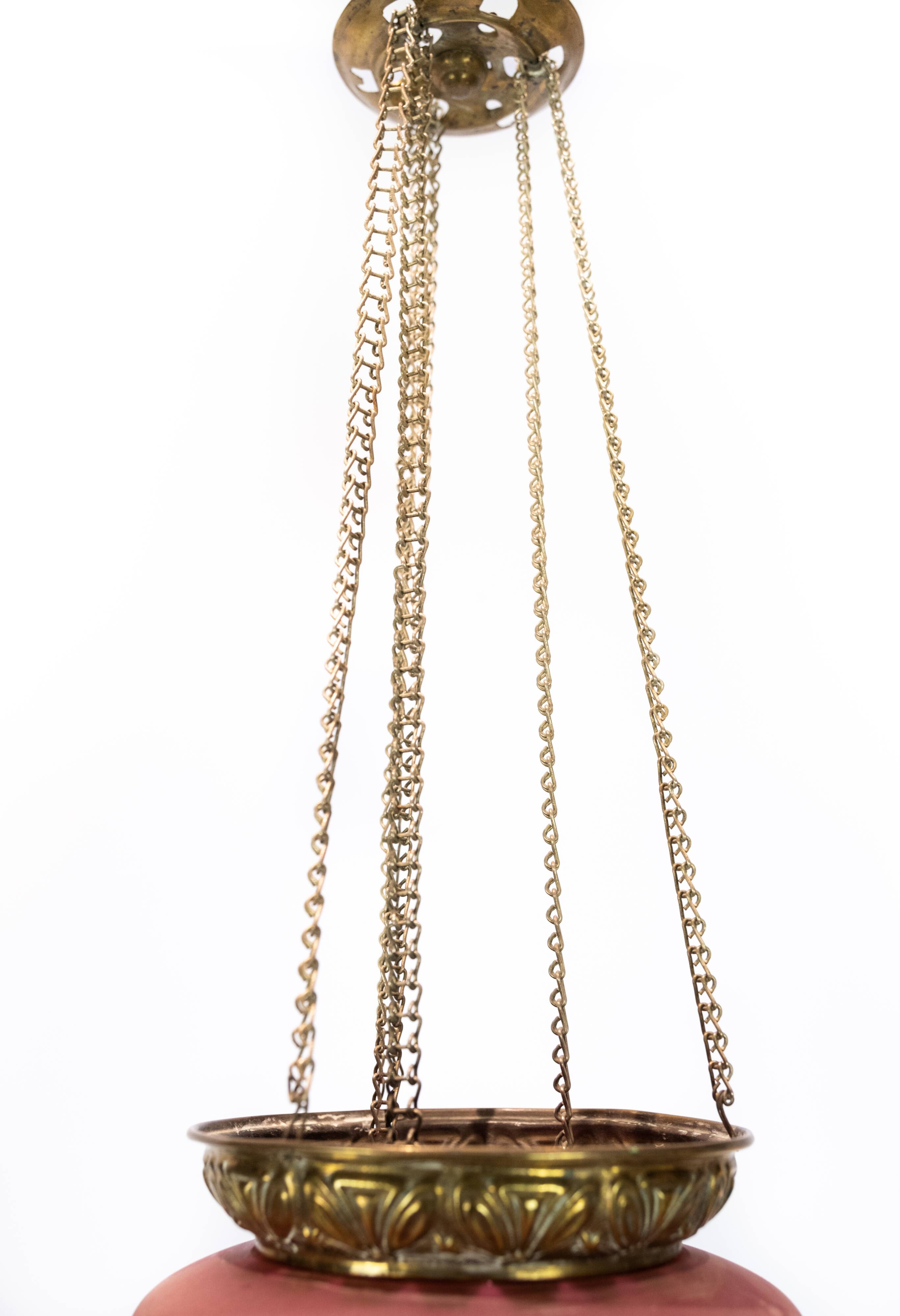 Antique pendant of pink opaline glass with brass edge and suspension from around 1860