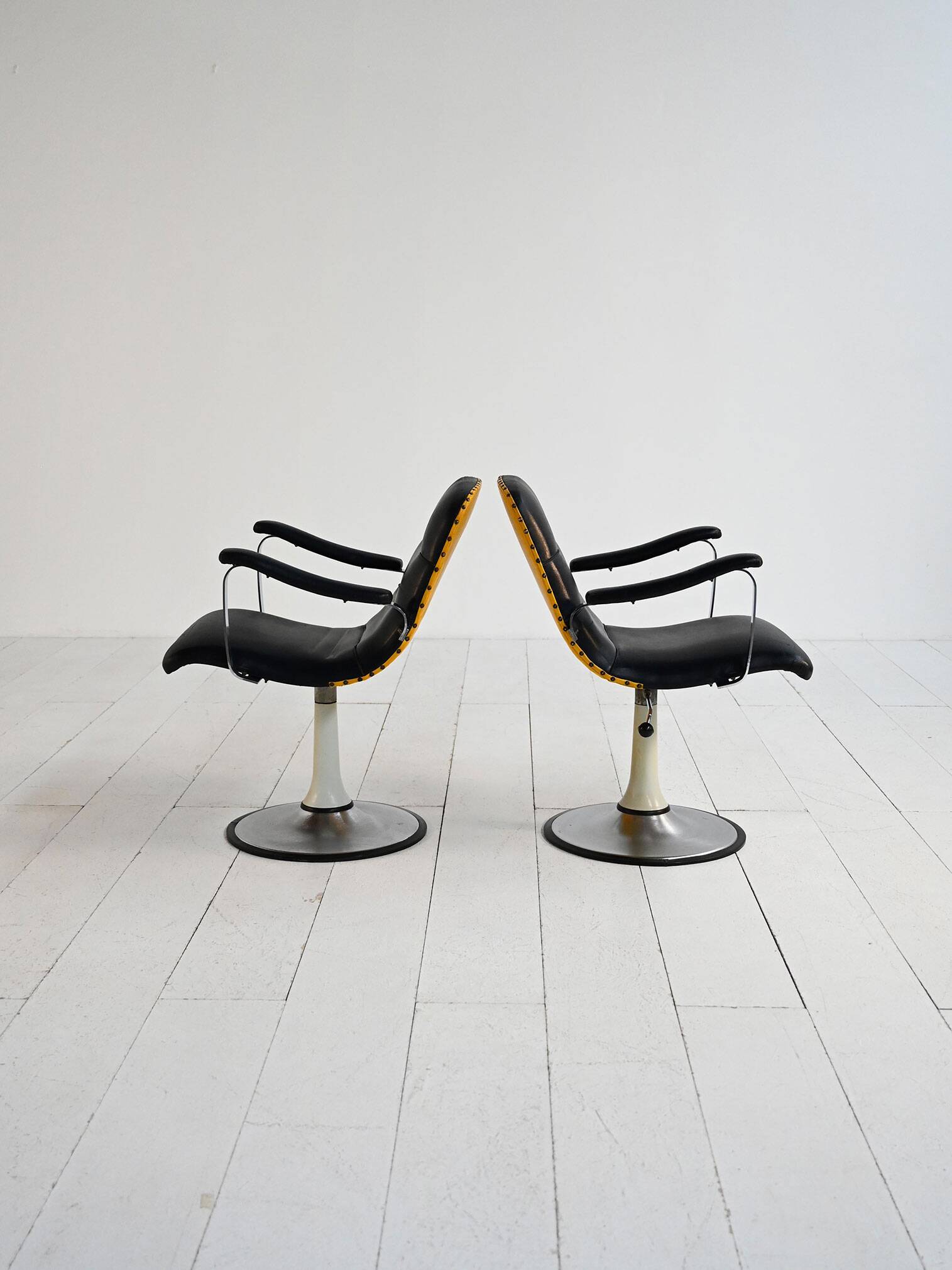 Pair of European 1970s swivel armchairs in faux leather and steel