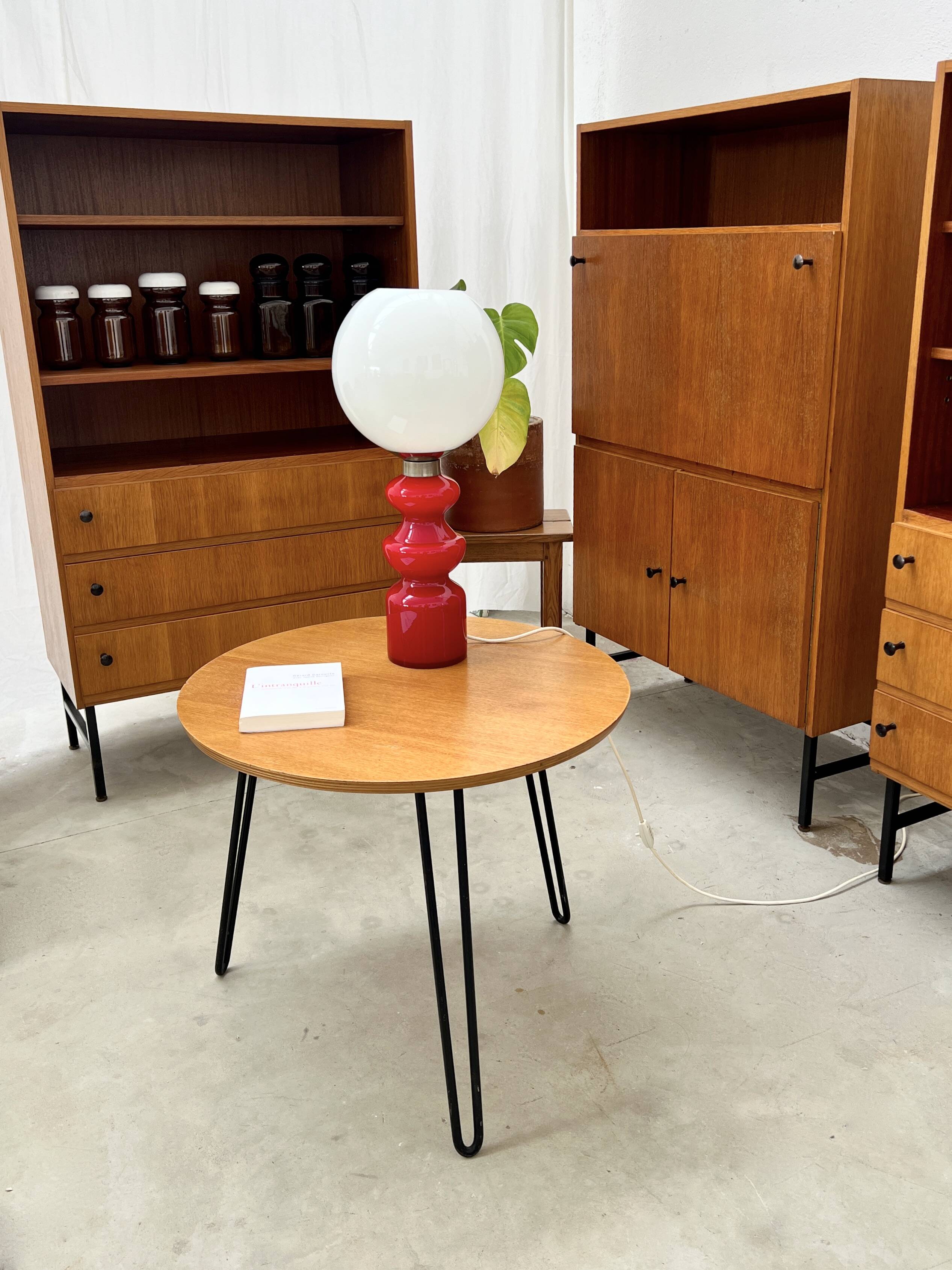 Round side table with black lacquered metal hairpin legs.