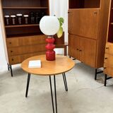 Round side table with black lacquered metal hairpin legs.