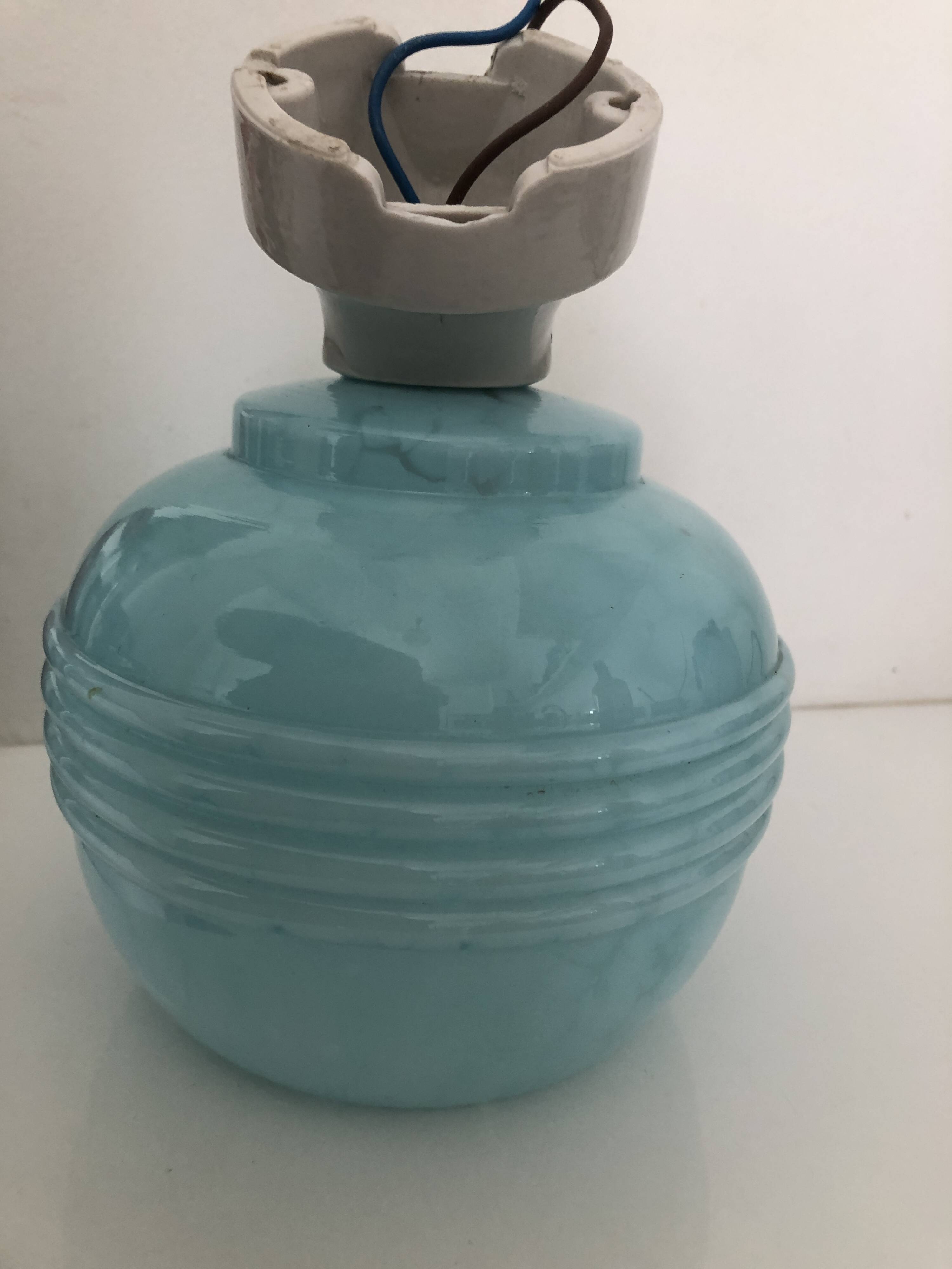 Wall light in ceramic with a light blue glass globe.