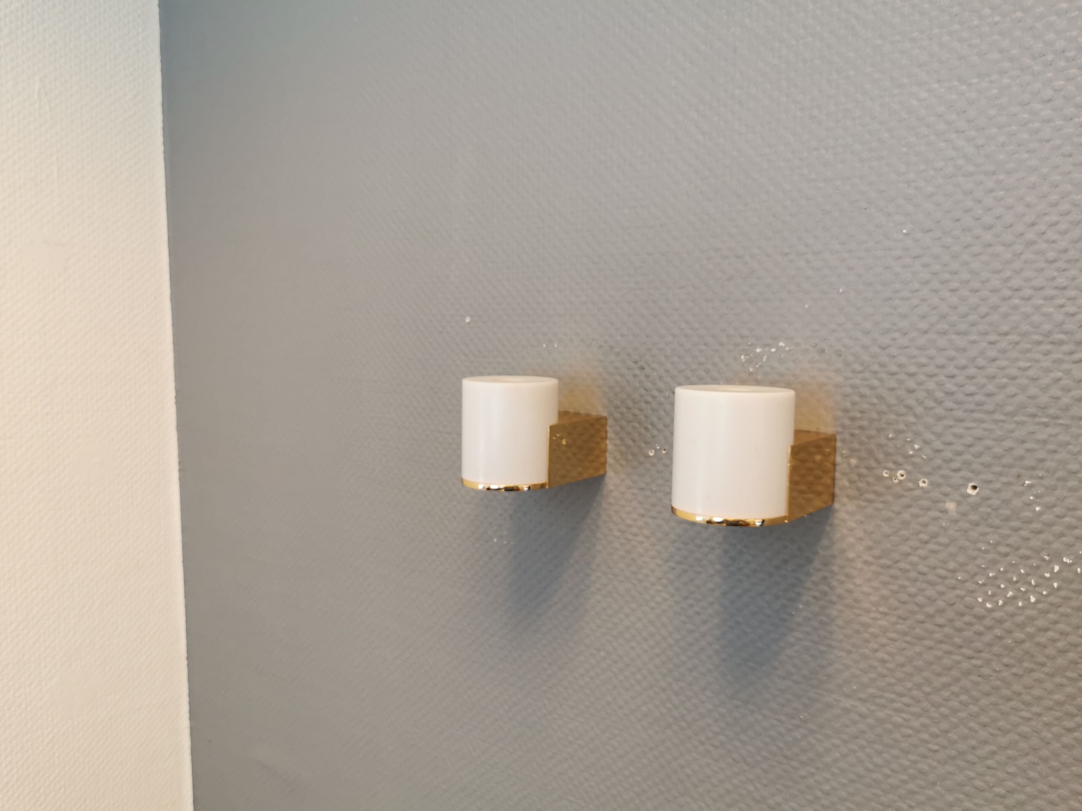 Wall lamps with milky white acrylic plastic shades and solid brass bases