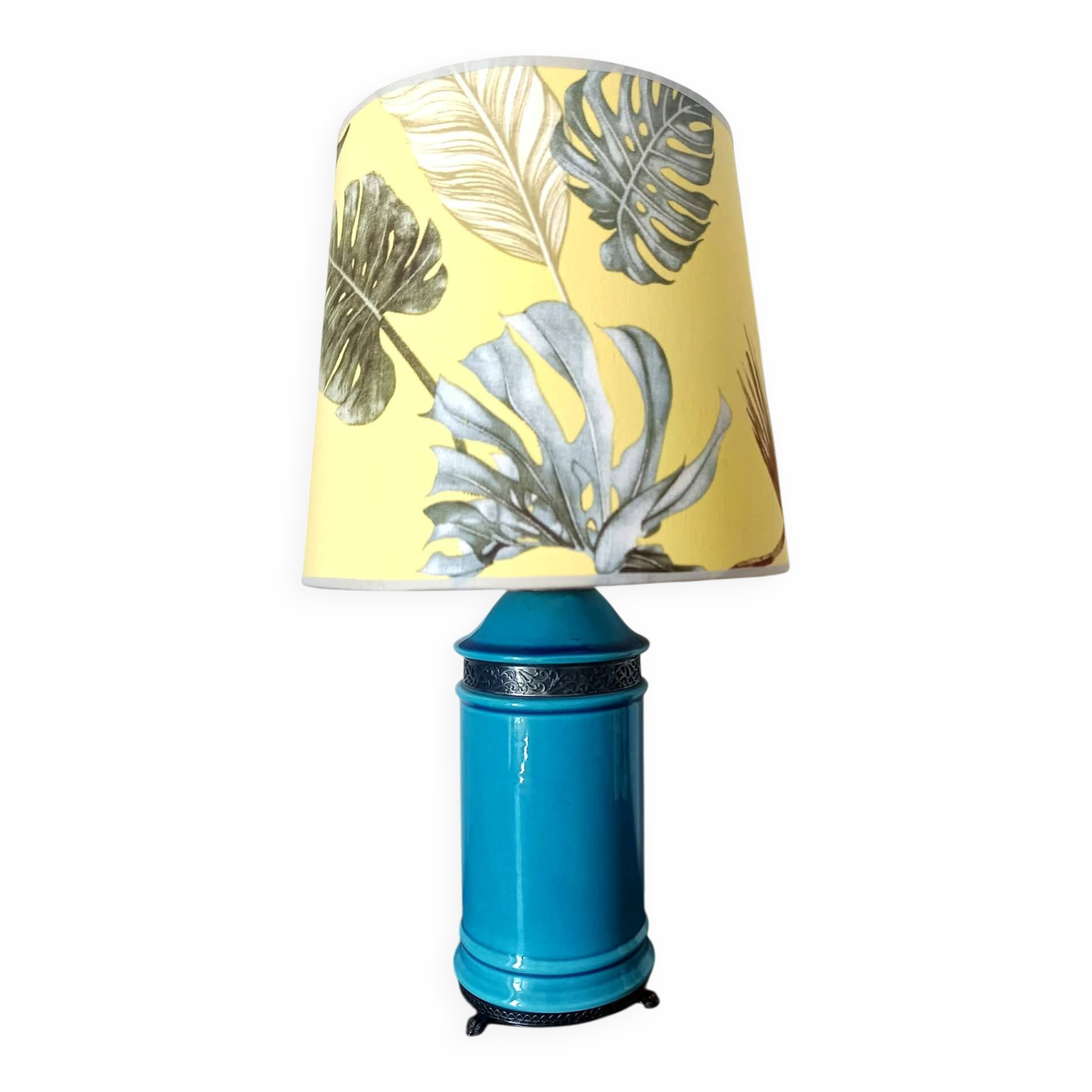Blue ceramic lamp with claw feet and foliage lampshade.