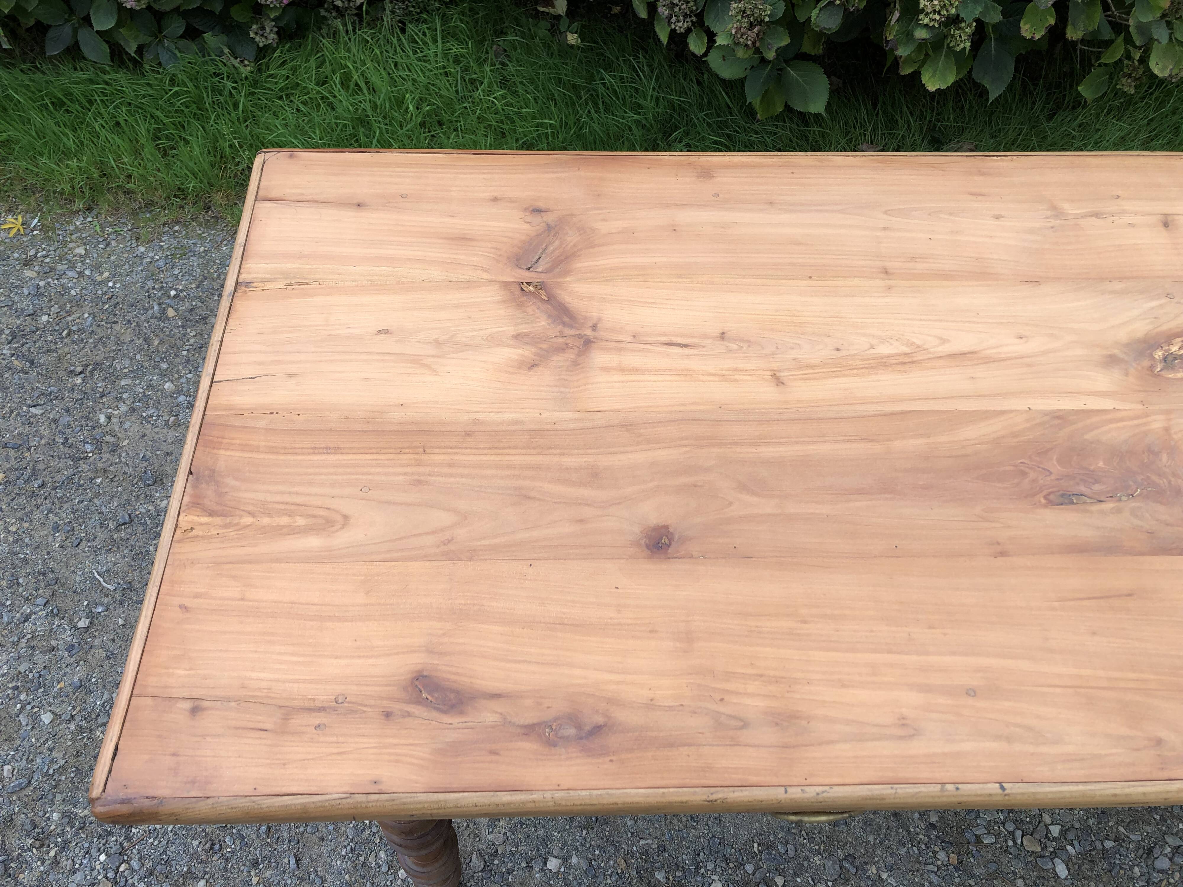 Antique Louis Philippe style farm table in solid cherry wood with 2 drawers and turned base.