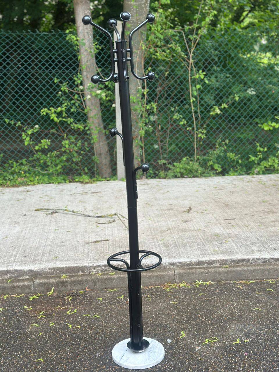 Vintage black metal coat rack with a white marble base.