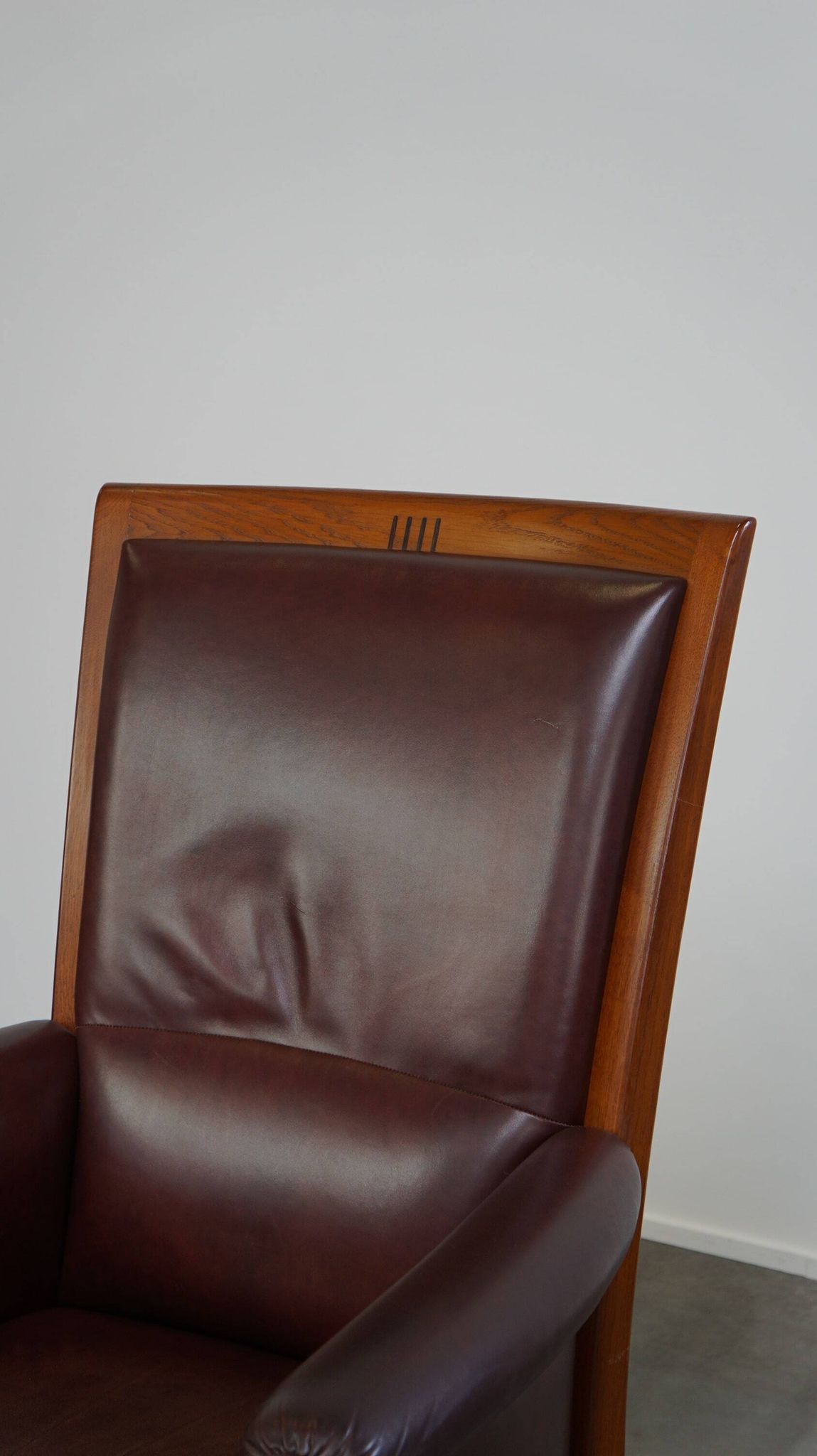 Very comfortable classic cowhide armchair with a high back in a mild Art Deco style