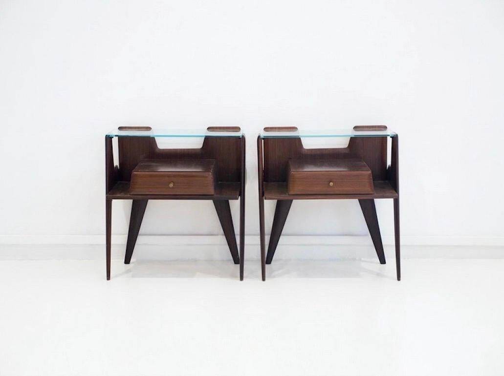 Pair of modernist Italian bedside tables in wood with a glass top.