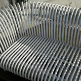 Rattan lounge with two two-seater sofas and a white coffee table.