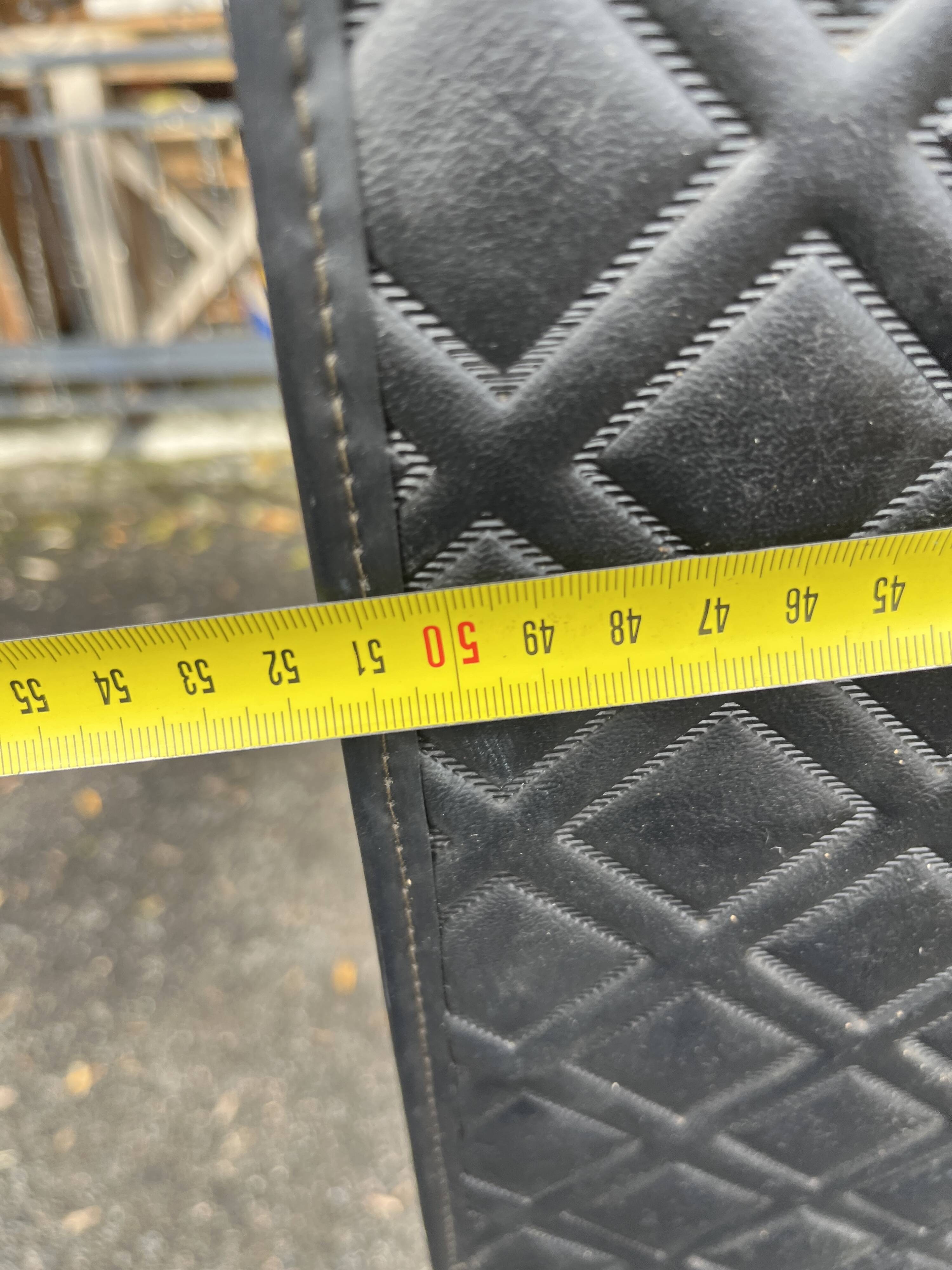 Contemporary wardrobe in black faux leather with diamond pattern and gold handles.