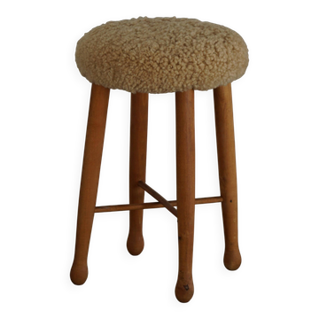Danish sculptural stool from the mid-century modern period with a lambswool seat, 1960s.