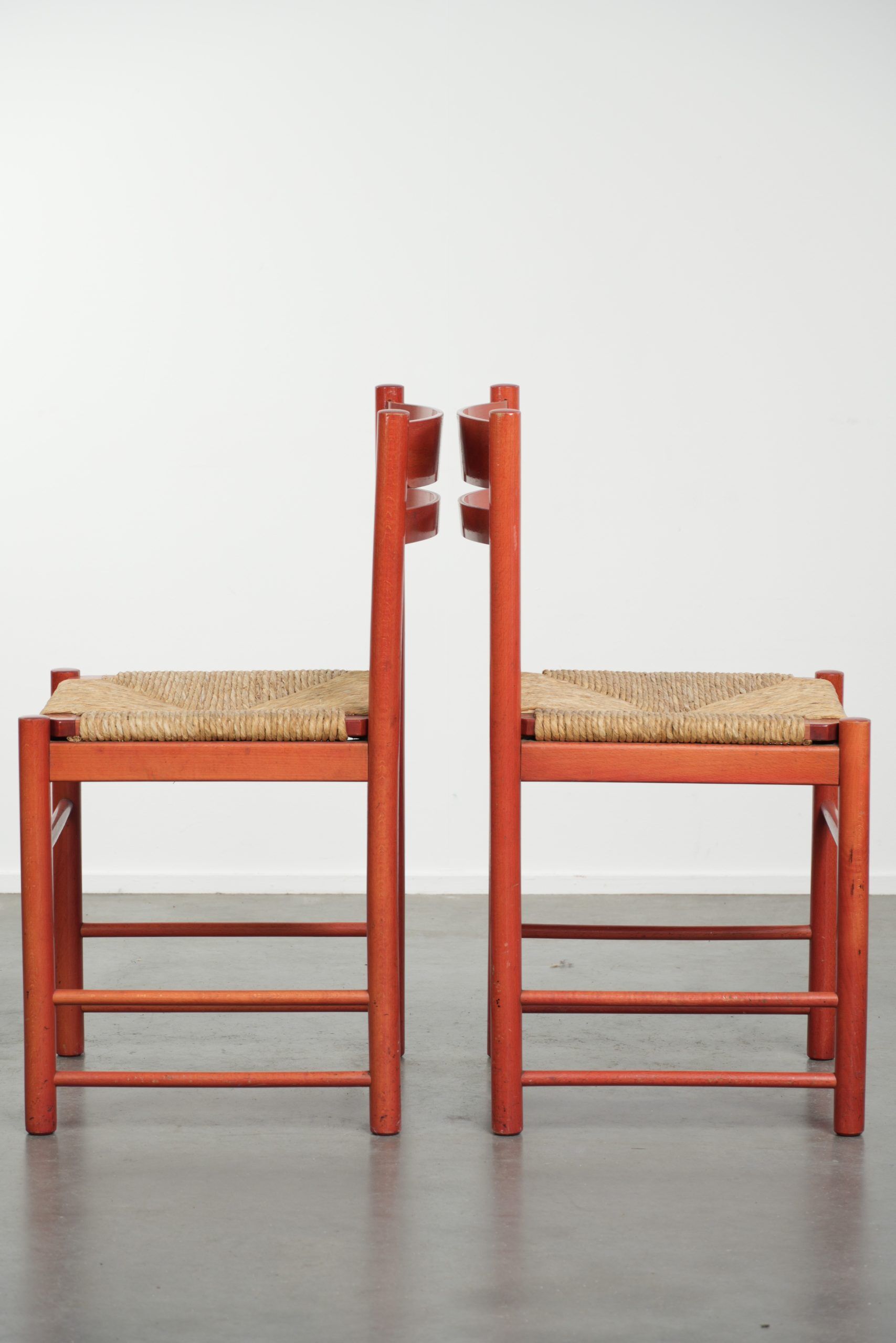Set of two red vintage wooden chairs from the 1970s with woven rattan seats