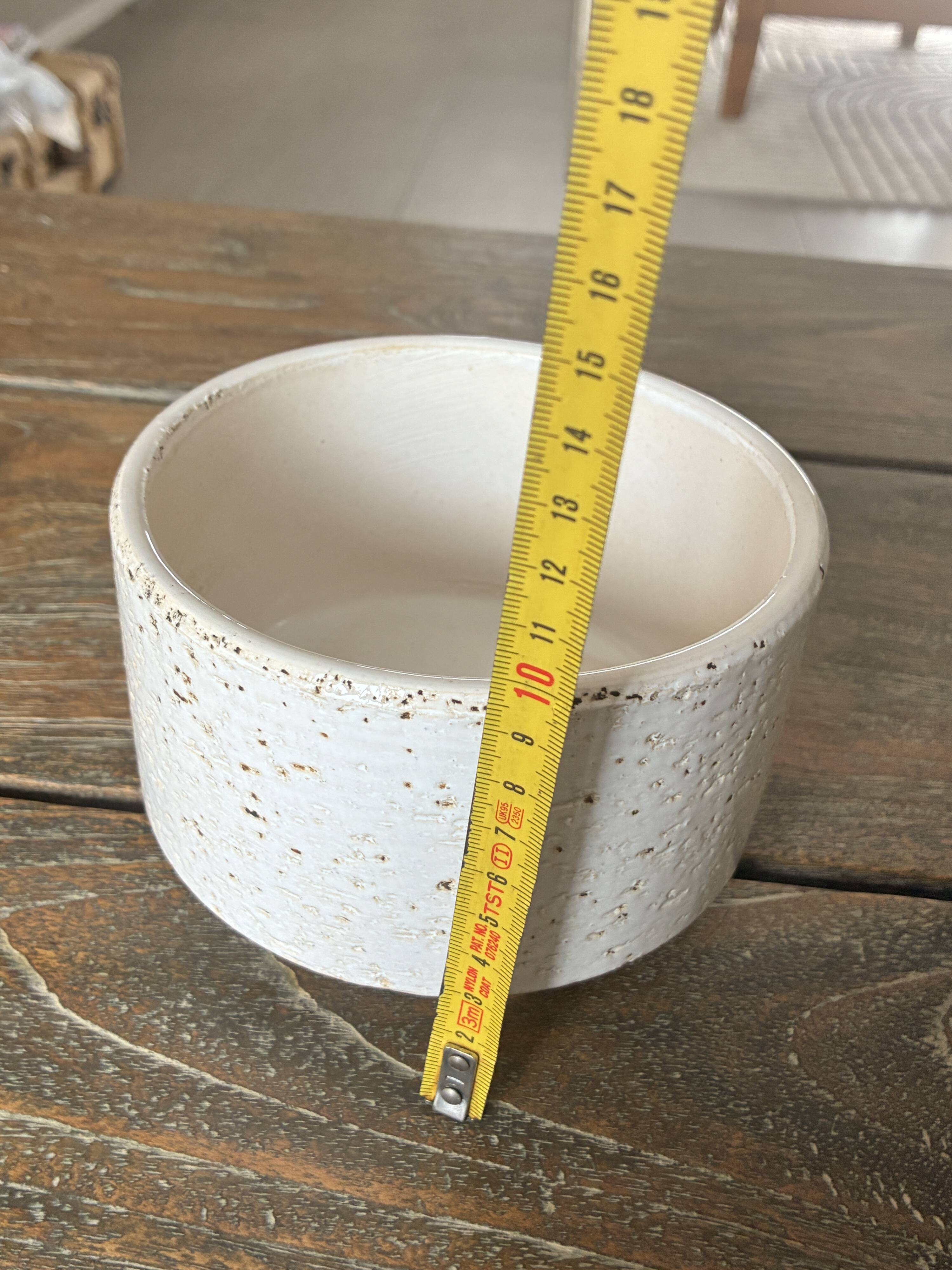 White ceramic vase with a textured effect.