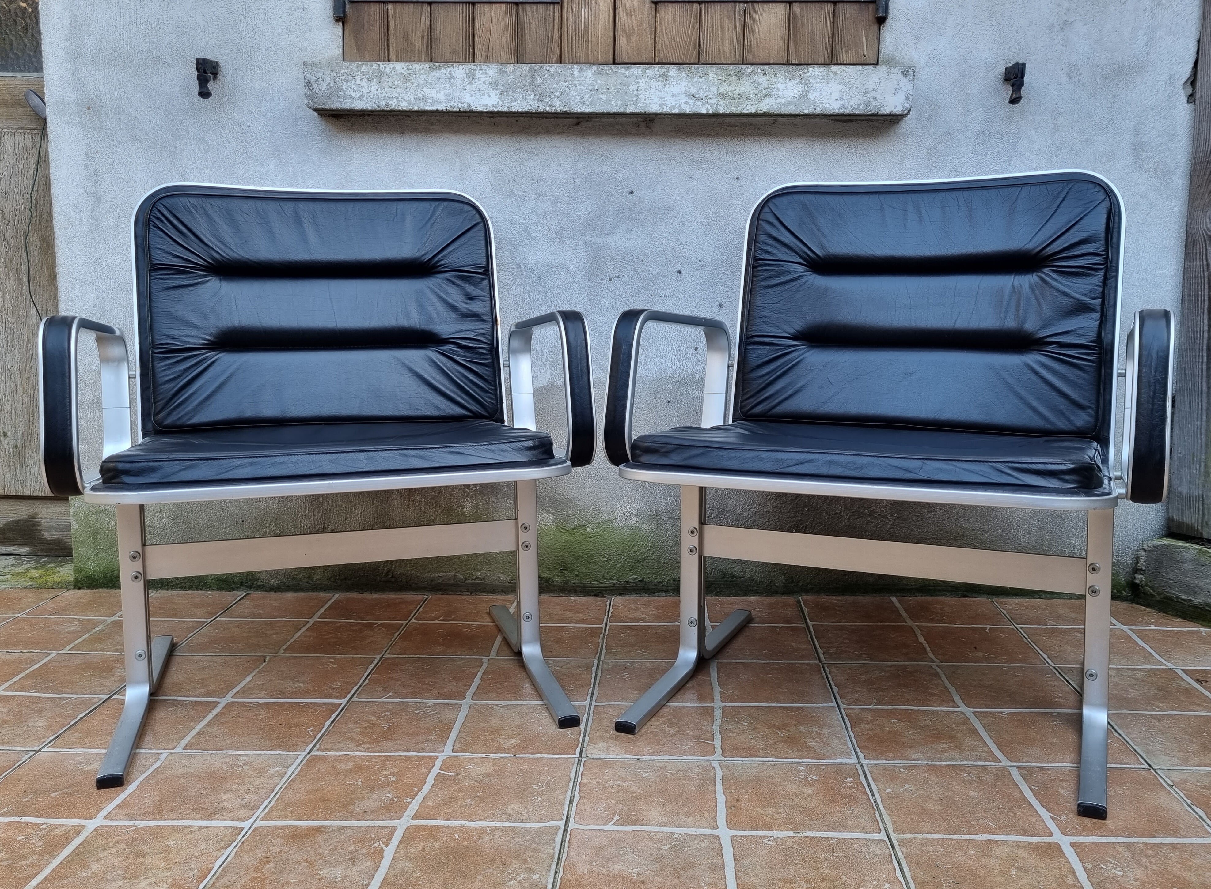Pair of vintage leather and aluminum armchairs, restored