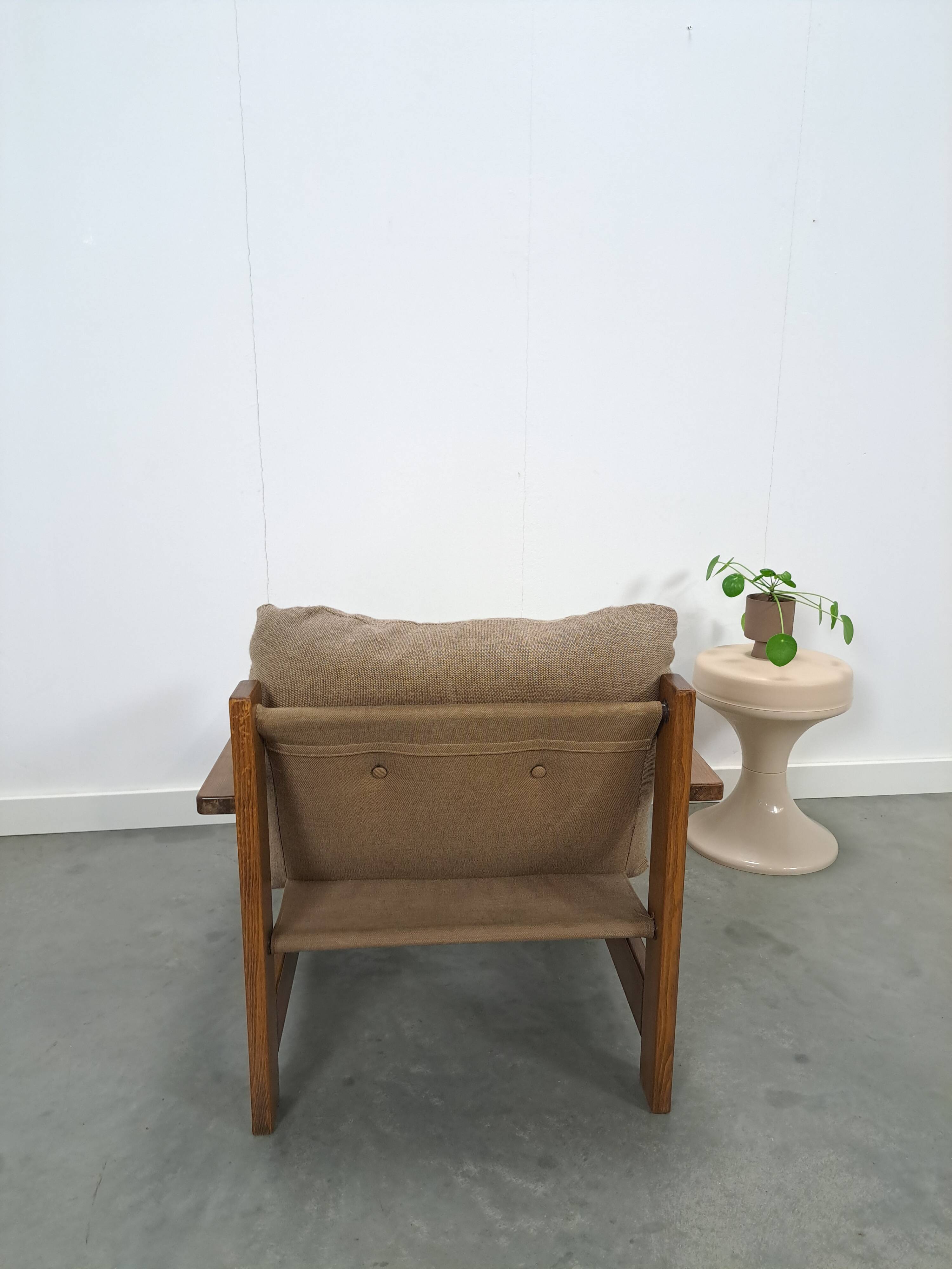Brown-grey armchair with an oak frame.
