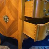 Large bow-fronted chest of drawers in blonde cherry with bronze ornamentation.
