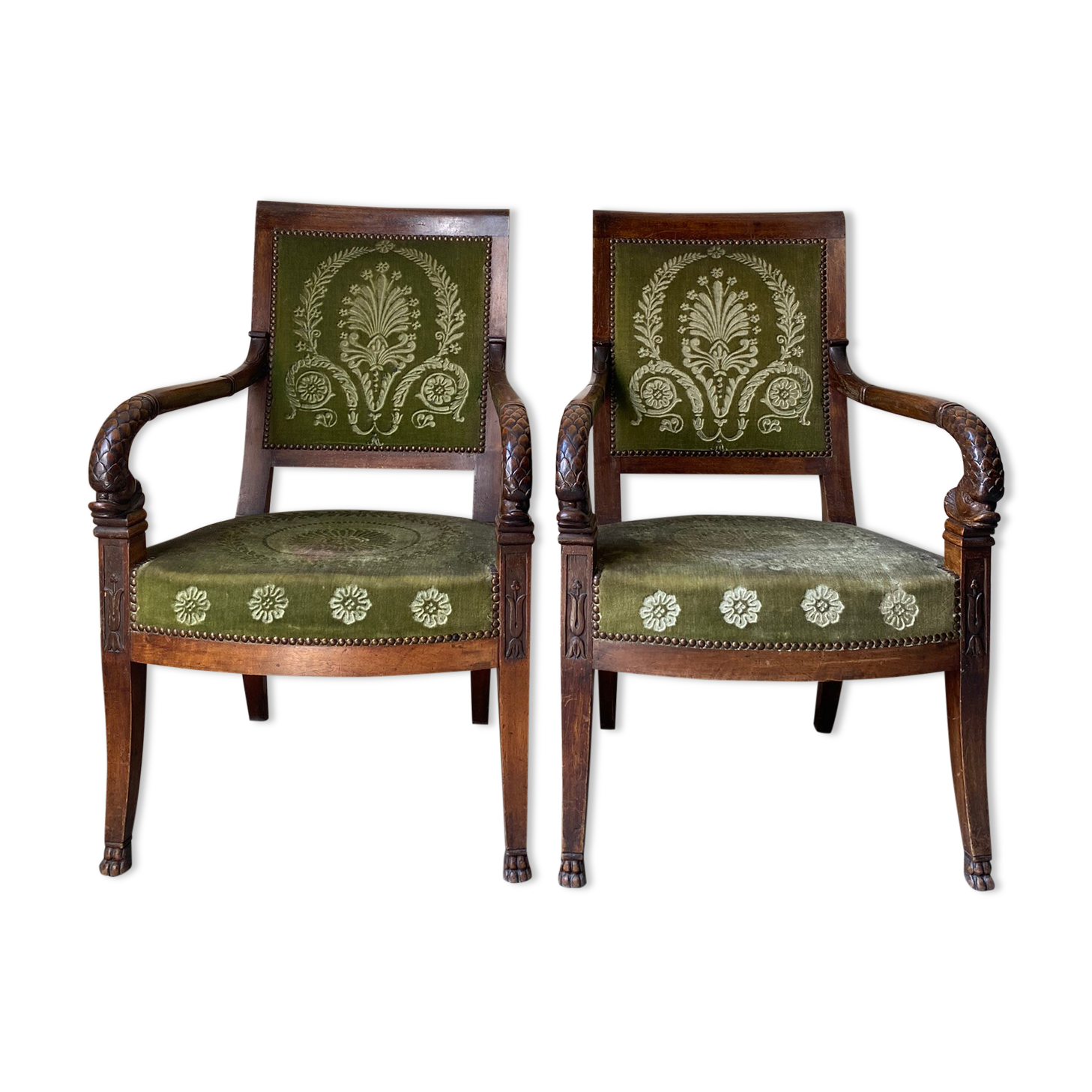 Paire de fauteuils empire en noyer teinté, tissus vert motif de palmette, sculptés têtes de dauphin