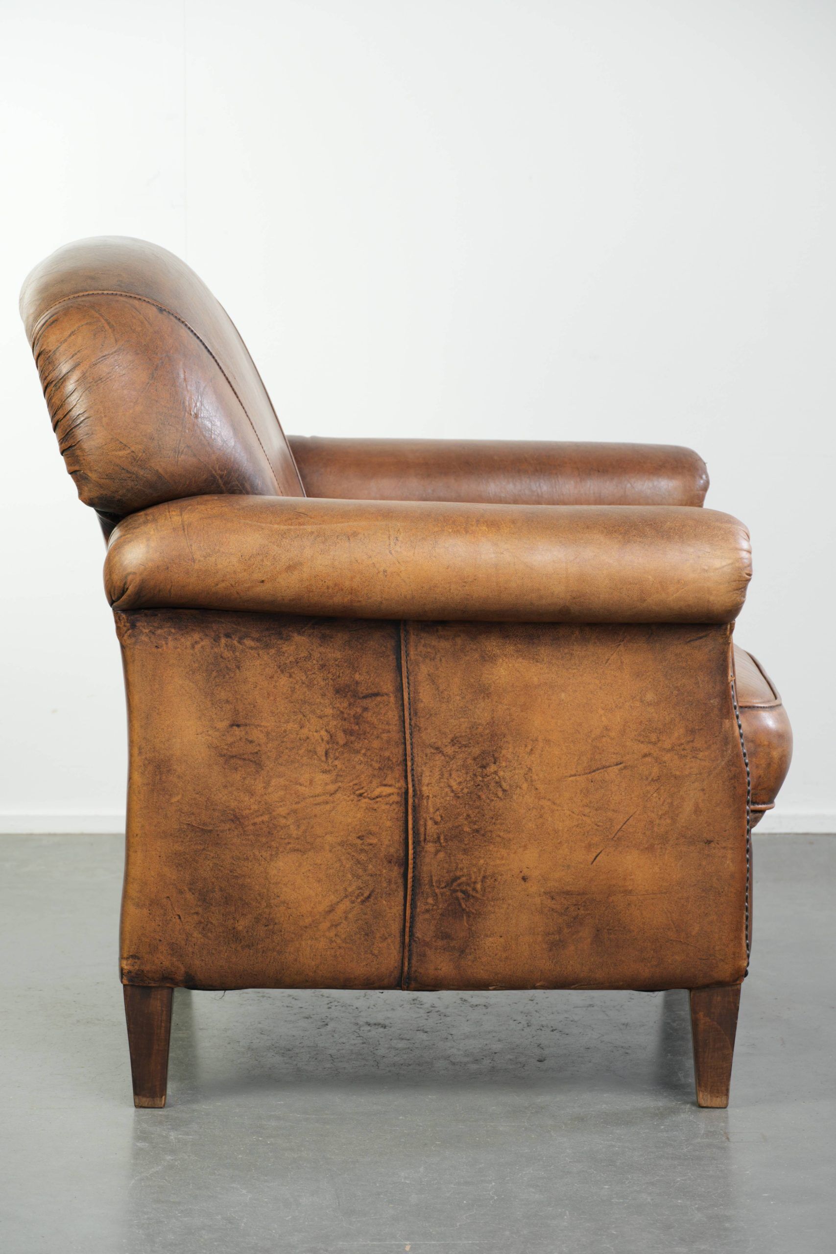 Comfortable characterful sheepskin armchair finished with decorative nails