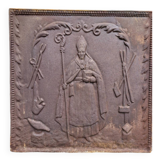 Plaque de cheminée en fonte XIX ème : évêque bénissant les outils de forgeron