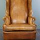 Old wingback armchair made of sheep leather in a correct condition