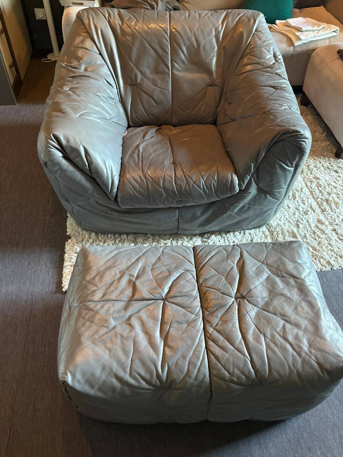 Sloop armchair and pouf from Ligne Roset in grey leather.