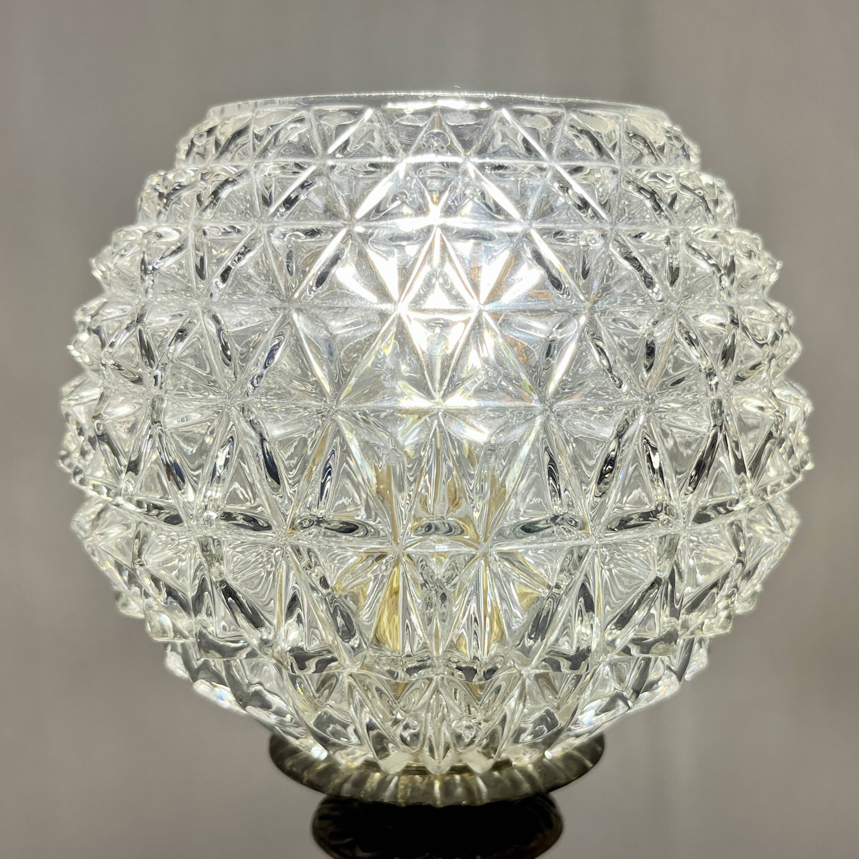 Antique brass foot lamp with glass globe and diamond point.