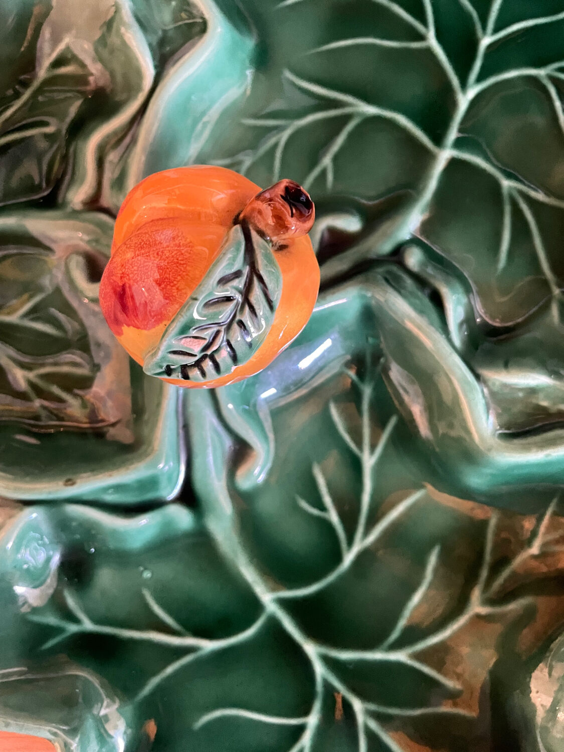 Old dish in green slip decor 3 vine leaves and an apple