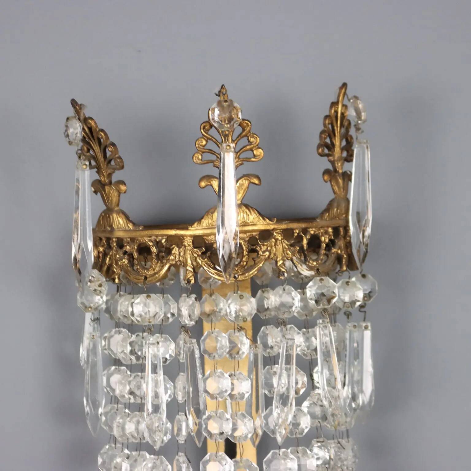 Antique wall sconces in gilded bronze with neoclassical motifs, 20th century.